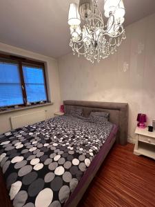 Un dormitorio con una cama grande y una lámpara de araña. en Apartment National Stadium Port Praski en Varsovia