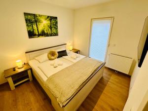 ein Schlafzimmer mit einem großen Bett und einem Fenster in der Unterkunft FeWo Buche mit Balkon in Bad Harzburg