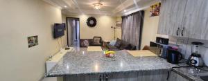 a kitchen with a counter top and a living room at Gentle home in Pretoria