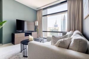 a living room with a couch and a large window at Frank Porter - Index Tower in Dubai