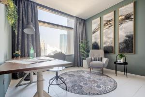 um escritório com uma secretária e cadeiras e uma janela em Frank Porter - Index Tower em Dubai