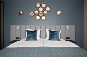 ein Schlafzimmer mit einem Bett mit zwei blauen Kissen in der Unterkunft Hotel du Nord Alster - auf der Uhlenhorst in Hamburg