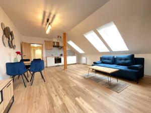 a living room with a blue couch and a table at Apartmán č.3 v bankovním domě in Kutná Hora