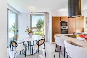 een keuken met een tafel en stoelen in een keuken bij Akamas Bay Villa 42 by BeCyprus in Neo Chorio