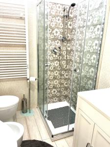 La salle de bains est pourvue d'une douche avec une porte en verre. dans l'établissement Minù house, à Scalea
