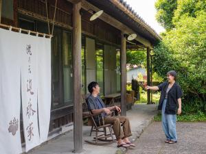 two people standing outside of a building with a man talking at 瀧乃元 近藤家（Kondoke-Inn) in Toon +19 photos