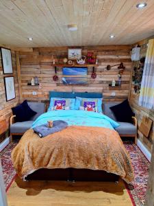 um quarto com uma cama e uma parede de madeira em LILAC COTTAGE cabin em Swafield