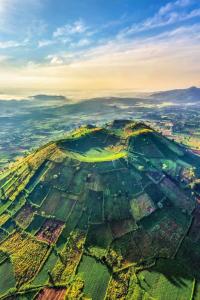 an aerial view of a field with mountains in the background at Ken House 1993 in Plei Kêp