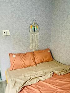 ein Schlafzimmer mit einem Bett und einem Traumfänger an der Wand in der Unterkunft Ken House 1993 in Plei Kêp