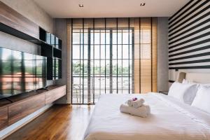 a bedroom with a large bed with towels on it at Beforesunset in Ban Chang Kham Luang