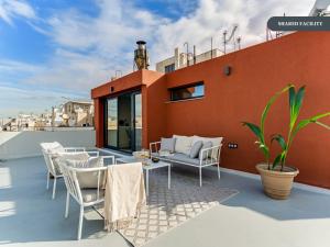 a rooftop patio with chairs and tables on a roof at Sanders Port Piraeus in Piraeus