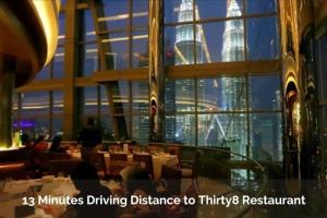 a restaurant with a view of the burj khalifa through the windows at KL City Family Suite Level38 in Kuala Lumpur