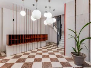 a hallway with a checkered floor and potted plant at Sanders Port Piraeus in Piraeus