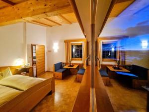 ein Hotelzimmer mit einem Bett und einem Wohnzimmer in der Unterkunft Residence Zirmer in Kastelruth