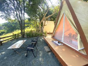 a group of chairs sitting next to a tent at Serene Khaokho in Ban Khao Ya Nua