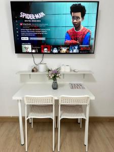 a white table and chairs with a tv on the wall at 54place​สะพานใหม่ดอนเมือง in Ban Don Muang