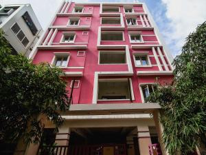 a pink building with a lot of windows at OYOFlagship Hillside Hotel Kukatpally in Kukatpally