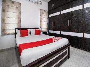 a bedroom with a large bed with red pillows at OYOFlagship Hillside Hotel Kukatpally in Kukatpalli