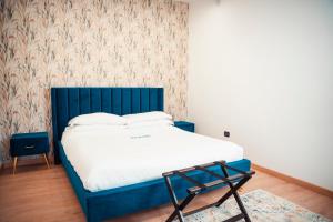 1 cama con cabecero azul en una habitación en SambaSS Boutique Apartment, en Capua