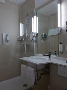 een badkamer met een wastafel en een spiegel bij Hotel du Nord Alster - auf der Uhlenhorst in Hamburg