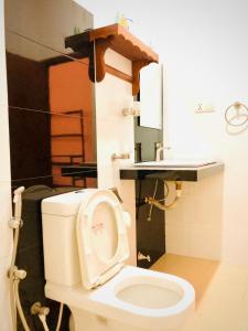 a bathroom with a white toilet and a sink at Mirissa Beach Inn in Mirissa