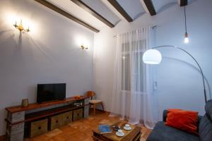 Cozy apartment near the center, Torres de Serrano في فالنسيا: غرفة معيشة مع أريكة وتلفزيون