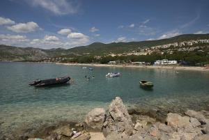 a beach with boats and people in the water at Apartman Nena in Klenovica