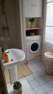 un bagno con lavandino e lavatrice di Appartement au coeur de paris à 1 kilomètre de la Tour Eiffel a Parigi Altre 14 foto