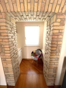 a room with a brick wall and a window at Via Umbria 25 Luxury Suites in Rome