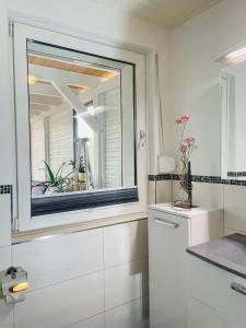 a bathroom with a mirror and a white sink at Restaurant Seeblick direkt am Schweriner See in Bad Kleinen