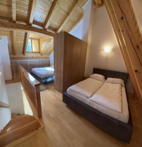 a bedroom with two beds in a room with wooden ceilings at BJELAŠNICA BEX APARTMANI in Bjelašnica