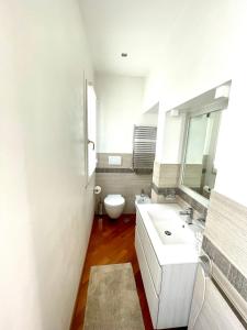 biała łazienka z toaletą i umywalką w obiekcie Via Umbria 25 Luxury Suites w Rzymie