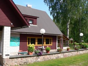 a house with a bench and flowers in front of it at Kivi Turismitalu in Vardi