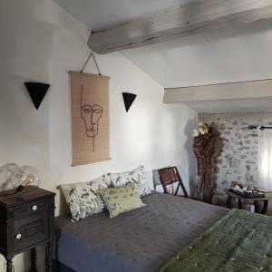 a bedroom with a bed and a table and a chair at Chambres du clocher in Vallon-Pont-dʼArc