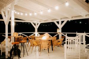 a patio with tables and chairs and lights at Malý Oslov Glamping in Oslov
