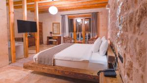 1 dormitorio con 1 cama y TV en una habitación en La Fairy Cappadocia Adult Only, en Uchisar