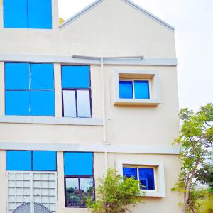 een gevel van een gebouw met blauwe ramen bij Mannat Inn Homestay (Mysore) in Mysore