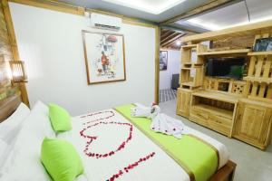 ein Schlafzimmer mit einem Bett mit zwei Spielzeugtieren darauf in der Unterkunft Green Bali Guest House in Munggu