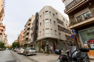 um edifício numa rua da cidade com uma moto estacionada em frente em Apartamento Mulhacen Centro em Granada
