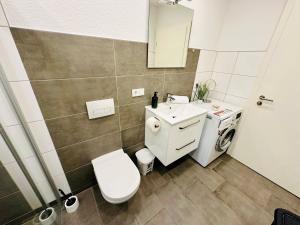 Un baño con un inodoro blanco y un lavabo. en FeWo Kastanie mit Balkon #Netflix #Innenstadtnähe von Harztraveler, en Bad Harzburg 15 fotos más