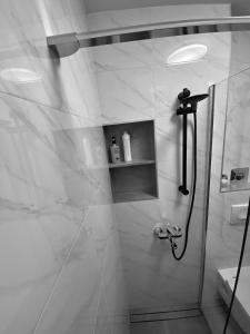 W łazience znajduje się prysznic ze szklanymi drzwiami. w obiekcie ASTORIA w mieście Varaždin