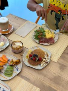 a table with plates of breakfast food on it at Jaca Hostel Funchal in Funchal