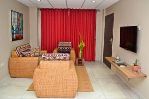 uma sala de estar com dois sofás e uma cortina vermelha em Acquah Place Residences em Acra