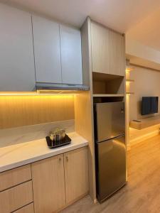 a kitchen with a stainless steel refrigerator and cabinets at Wawa Guesthouse Pollux Habibie Batam Tower A 17 in Kangboi