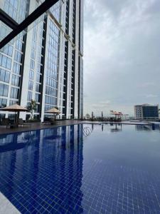 a large swimming pool in front of a tall building at Wawa Guesthouse Pollux Habibie Batam Tower A 17 in Kangboi