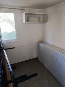 une petite chambre avec une fenêtre et un radiateur dans l'établissement Charmant mobil-home 97, à Narbonne