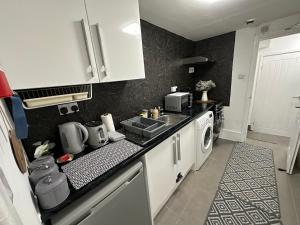 a kitchen with a sink and a stove top oven at Cosy Cambridge Centre Flat in Chesterton