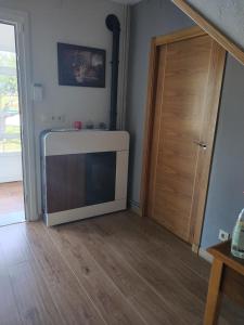 ein Wohnzimmer mit einem TV und einer Tür in der Unterkunft A casa de Dora da Estrada in A Estrada