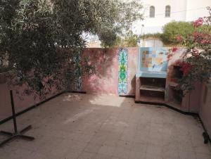 a courtyard with a wall with a gate with graffiti at Flamant rose in Houmt Souk