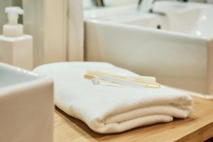 a pile of towels sitting on a counter in a bathroom at Hostel Mange Tak in Hiroshima